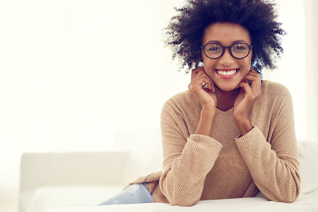 Young woman smiling while exploring the benefits of NAD+ for healthy aging and wellness